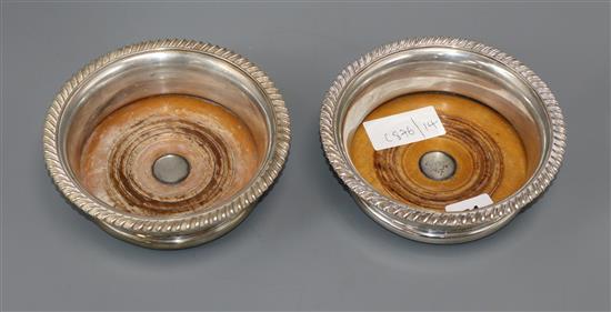 A pair of silver plated wine coasters